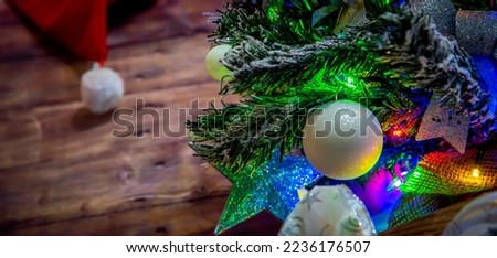 Close up of a Christmas tree with a wooden background and a Santa hat