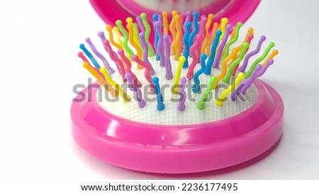 A beautiful, colorful girl's toy comb with a small mirror inside