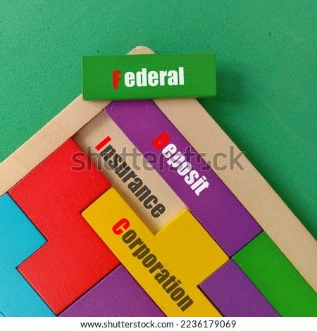 Business FDIC federal deposit insurance corporation concept. Text written Federal, Deposit, Insurance and Corporation at wooden puzzle isolated green background 