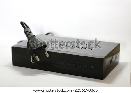 set top box or often called STB, a digital television signal converter, black in color with a plain white background