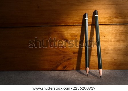 highlighted pencils standing in front of wooden wall. copy space