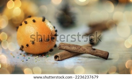 Christmas table. background image of cinnamon sticks, oranges and cookies on wooden background. photo with copy space. beautiful bokeh effect from a garland.