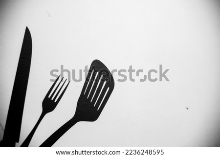 shadow of kitchen utensils on a dark background