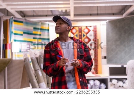 Black ethnic man shopping in a carpet supermarket, buying prices