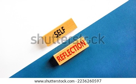 Self reflection symbol. Concept word Self reflection typed on wooden blocks. Beautiful white and blue paper background. Business psychological and self reflection concept. Copy space.