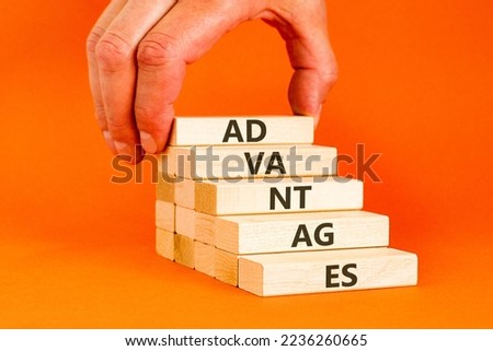 Advantages symbol. Wooden blocks stacking as step stair on orange background, copy space. Businessman hand. Word 'advantages'. Business and advantages concept.