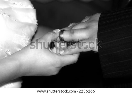 bride places ring on grooms finger