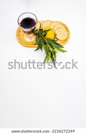Rosh hashanah holiday jewish new year, white vertical background with tangerine on a branch, traditional bread and a glass of red wine on a wooden tray.
