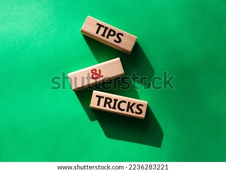 Tips and tricks symbol. Wooden blocks with words Tips and tricks. Beautiful green background. Business concept and Tips and tricks. Copy space.