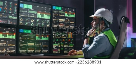 Main engineer following the plant process using Industry 4.0. Operator control process of production uses computer screens with SCADA system  Royalty-Free Stock Photo #2236288901