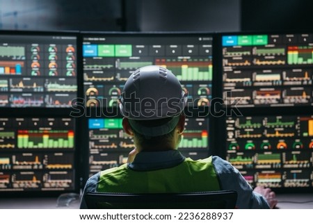 Main engineer following the plant process using Industry 4.0. Operator control process of production uses computer screens with system 