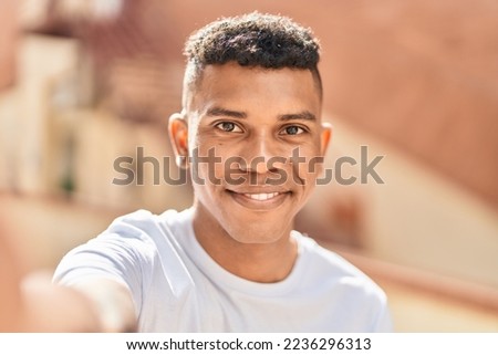 Young latin man smiling confident making selfie by the camera at street