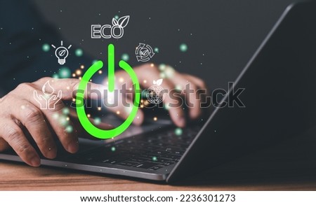 Man uses his finger to press button to turn off, closed, shut down laptop computer on desk, before going home for saving energy, save global environment. reduce global warming. world environment day Royalty-Free Stock Photo #2236301273