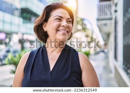 Middle age hispanic woman smiling happy and confident outdoors on a sunny day Royalty-Free Stock Photo #2236312549