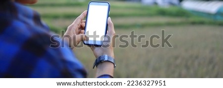 A woman's hand is using a mobile phone by touching the screen. agriculture banner.