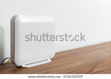 Advertising concept of internet provider services. High-speed connection at home or in the office. Close up view of white router with fiber line with lan cable. Modern network technology, copy space Royalty-Free Stock Photo #2236332929
