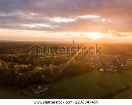 Amazing colorfull sunset in german small town with forest shot from above by a drone providing an areal view in a Social Media Format.