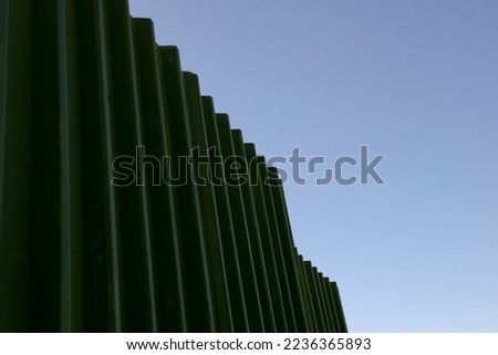Industrial background: green metal Garden iron fence,  in perspective. 