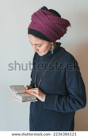 Young jewish woman with covered head prays with siddur (jewish prayer book) in her hands (64) Royalty-Free Stock Photo #2236386121