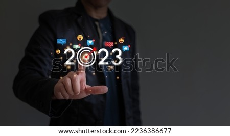 Man is pointing finger to year 2023, Like icon, heart smiley shocked and little lights surround year 2023, goal setting concept for coming new year.