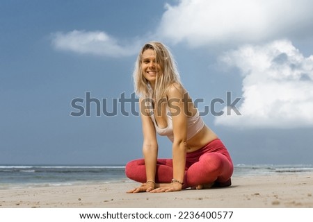 Picture of beautiful young fitness woman outdoors in the beach looking at camera