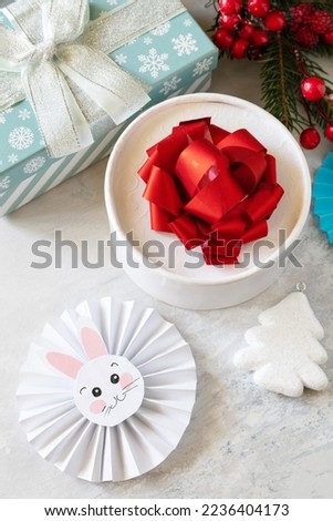 Winter greeting card. Christmas background with Christmas tree, gifts boxs and symbol of year lunar chinese calendar, year of the rabbit. 