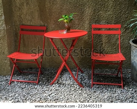 Red iron chairs and tables look attractive in the backyard