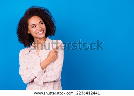Portrait of pretty positive lady look indicate finger empty space proposition isolated on blue color background