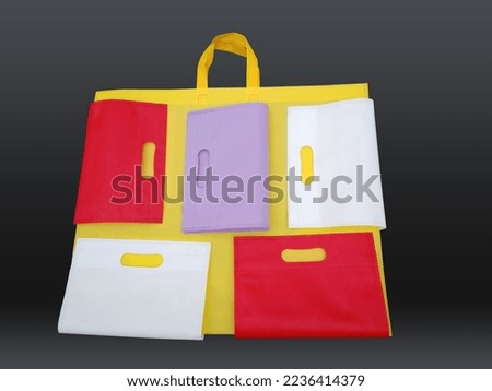 top view of few shopping bags isolated on black background. Fabric material non woven bags. Package collection reusable tote eco bags.