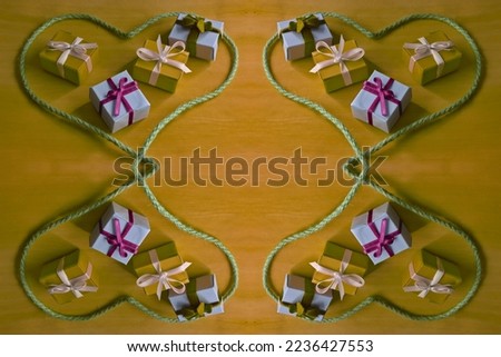 four hearts facing each other formed from string and in the middle are wrapped Christmas presents with a ribbon on a yellow background