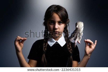 a girl in a Wednesday Addams costume style Royalty-Free Stock Photo #2236431315