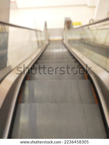 Blurred view from above to perspective escalator stairs inside shopping mall, successful career advancement concept