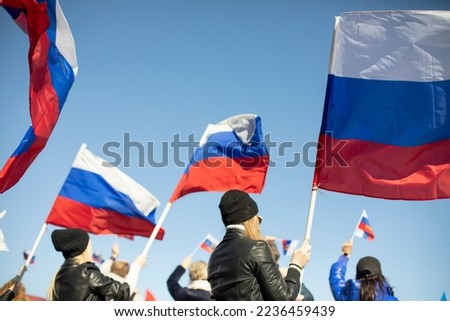 Girl holds flag of Russia. Government rally in Russia. National flag of Russian Federation. Rally in support of state policy.