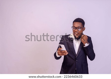 excited young black business man using his phone