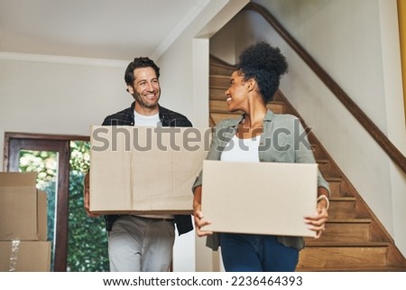 Couple homeowners moving in, carrying boxes and unpacking in new purchased home as real estate investors. Smiling, happy and cheerful interracial man and woman, first time buyers and property owners Royalty-Free Stock Photo #2236464393