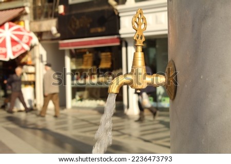 A tap with tiny water coming out of it. High quality photo