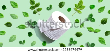 A roll of toilet paper with green leaves - flat lay Royalty-Free Stock Photo #2236474479