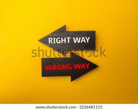 Arrow wooden board with the word RIGHT WAY WRONG WAY on yellow background.