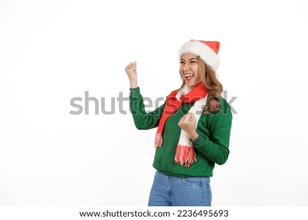 Attractive excited asian female in green sweater with santa hat on christmas isolated on white background.