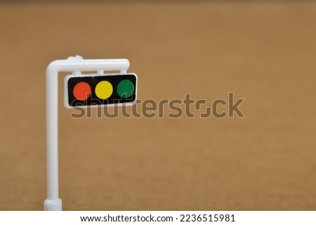White toy traffic light isolated on a brown background.
