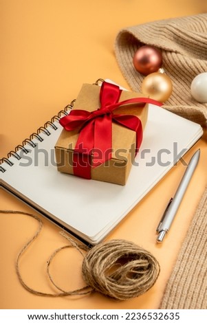 Coffee, Gifts, notepad and christmas decorations on yellow table. Christmas or new year concept. Flat lay, top view.