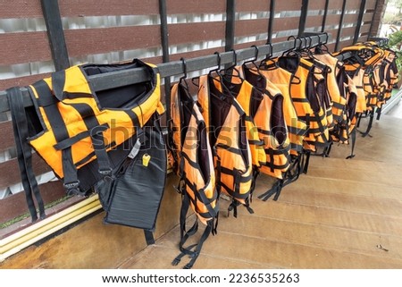 Bright marine life vest signal jackets close up, safety on water tourism activity and watersports. Royalty-Free Stock Photo #2236535263