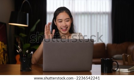 Smiling young asian woman freelancer having video call, chatting online via laptop computer.
