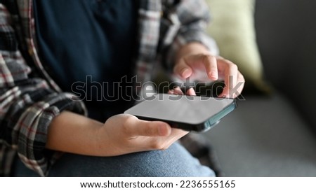Close-up image, A female in flannel shirt using her smartphone to contact her coworker or check her social media.