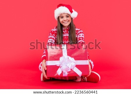 new year. cheerful santa teen girl with new year present sit in studio. teen girl
