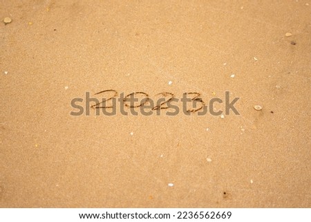 Happy New Year 2023 is coming concept sandy tropical ocean beach lettering nature background
