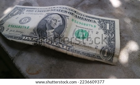 Old and crumpled USD Cash money. US dollars currency notes in one dollar denomination. Grey background.