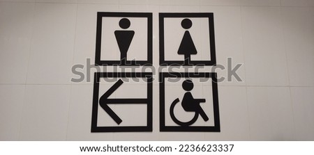 a sign inside a mall to indicate toilets and exits
