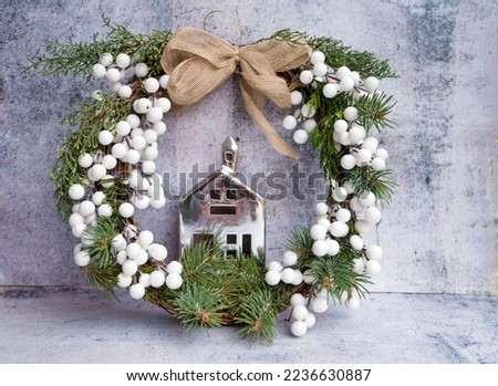 Christmas  pine wreath with decorative silver toy house 
