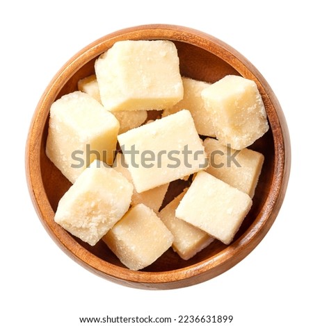 Grana Padano cheese cubes, in a wooden bowl. Italian hard cheese chunks, similar to Parmesan, crumbly-textured, with strong savory flavor and slightly gritty texture, made from unpasteurized cow milk. Royalty-Free Stock Photo #2236631899